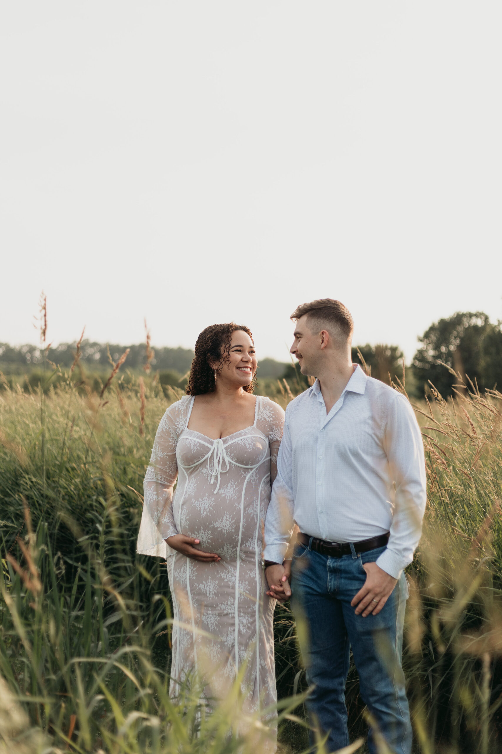 couple standing in field facing each other